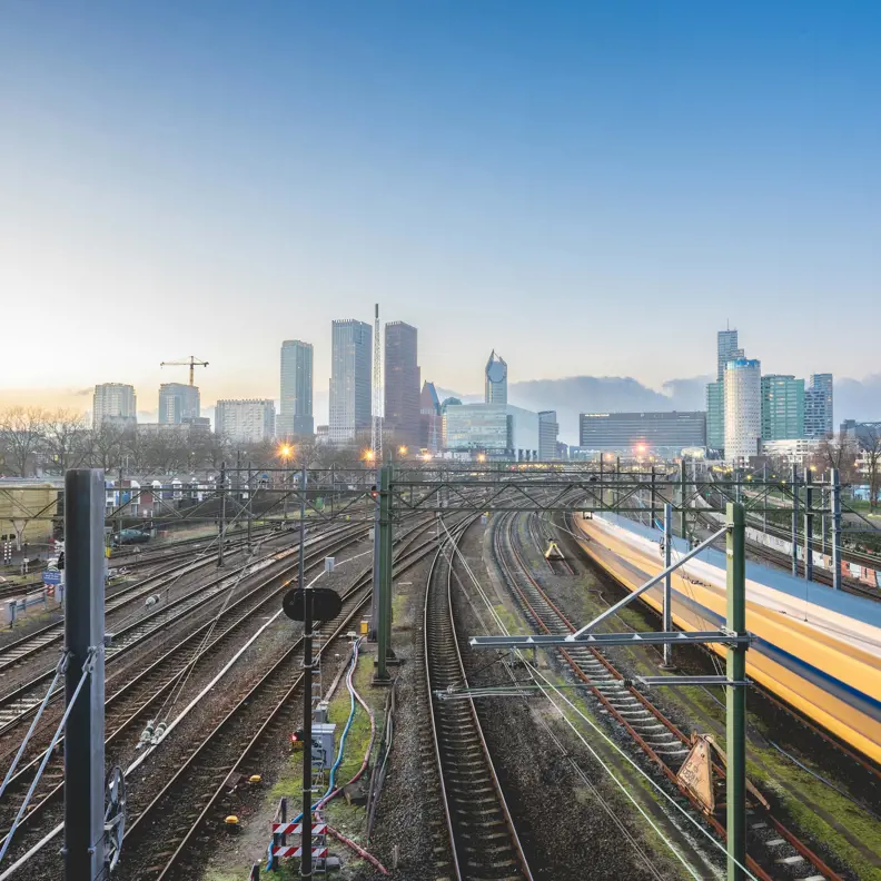 Afbeelding van electriciteitsnet van de ns met gebouwen op de achtergrond